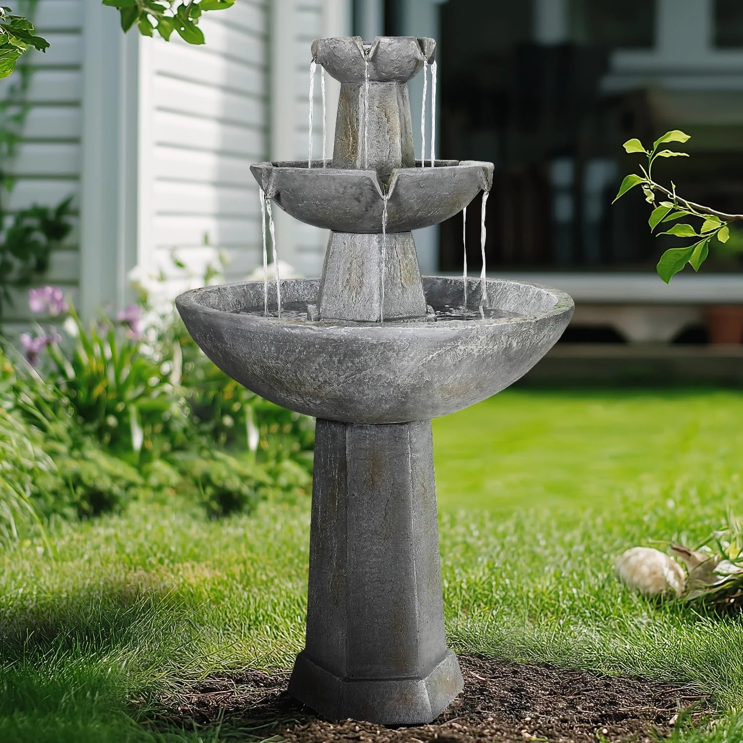 A person gently scrubbing the glass bowl of a glass sunflower bird bath with a soft brush and vinegar solution